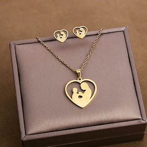 Detail of gold heart necklace and studs with mother-child silhouette in jewelry gift box