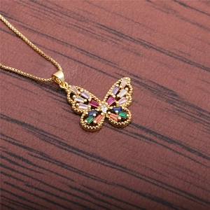 Collier papillon doré avec zircons colorés sur un support de fond en bois