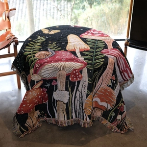 Woven mushroom and snail tapestry with tassels used as a vintage decorative tablecloth