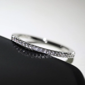 Vue macro d'une bague éternité en argent avec zircons brillants sur surface noire