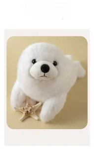 Dettaglio frontale della foca di peluche bianca con texture morbida e occhi neri