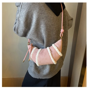 Detailansicht der rosa Wildleder-Hobo-Tasche mit weißen Pelzstreifen und Knotengurt am Model