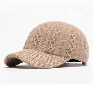 Detailed close-up of khaki knitted baseball cap with textured diamond knit pattern