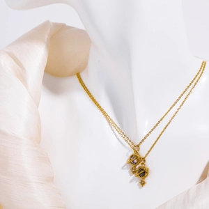 Detail of vintage double-layer 18K gold planet necklace with purple and blue gemstones