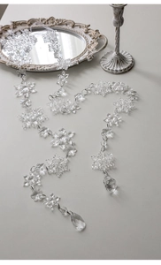 Close-up of acrylic snowflake ornaments with faceted crystal pendants for Christmas decor