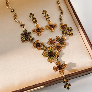 Détail d'une parure de bijoux vintage fleurs avec strass ambrés dans son écrin cadeau