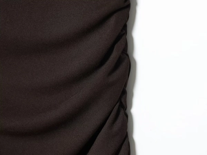Dettaglio ravvicinato della trama del tessuto nero a pieghe con maglia finissima