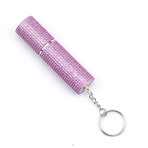 Macro detail of portable pink rhinestone perfume bottle with silver keychain