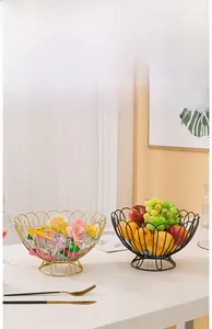 Close-up of matte black and gold metal wire fruit baskets with elegant hollow designs