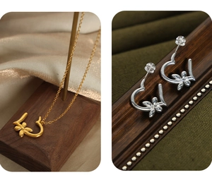 Detailed macro view of heart and flower pendant necklace and earrings in gold and silver