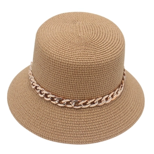 Detail of khakhi straw hat featuring intricate weave and rose gold metal chain trim