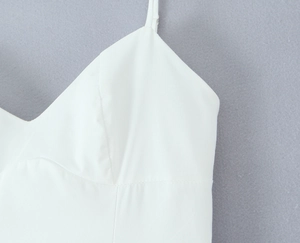 Détail de la coupe en V et des fines bretelles sur une robe longue blanche élégante