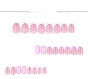 Close-up of pink and white press-on nails with floral patterns and 3D heart designs