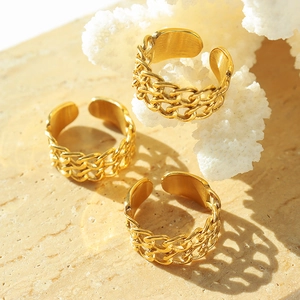 Three gold chain-link adjustable stainless steel rings displayed on beige stone
