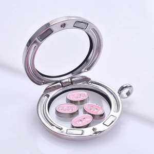 Macro shot of silver magnetic locket with pink hope charms and polished glass frame