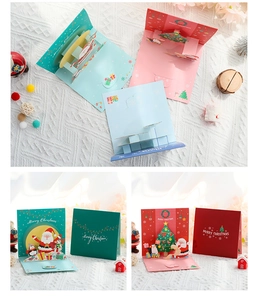 Collage of 3D Christmas cards with Santa and Penguin pop-up designs on white fabric