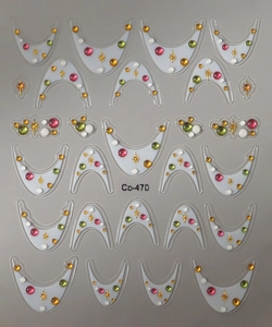 Detailed close-up of nail art stickers featuring colorful rhinestones and gold stars