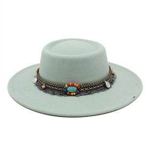 Détail d'un chapeau en feutre bohème avec ruban tressé coloré, franges et pierre turquoise