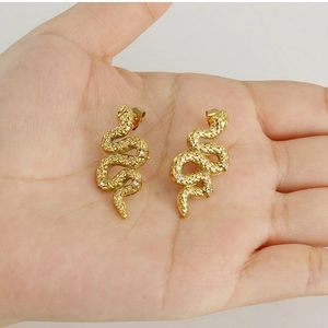 Macro dei piccoli orecchini a serpente in acciaio inossidabile dorato 18K con micro zirconi
