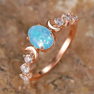 Macro detail of rose gold vintage oval opal ring featuring moon design and zircon accents