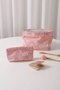 Detailed macro view of pink cotton linen makeup bag with white floral embroidery textures