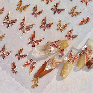 Close-up of amber butterfly nail art stickers with white edges and 3D Dreamland effect