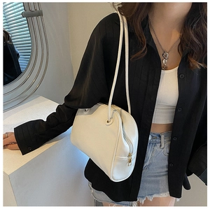 White minimalist tote bag shown on shoulder of model for urban fashion style