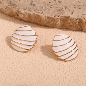 Macro detail of oval sailboat earrings in 18K gold plated steel with white enamel finish