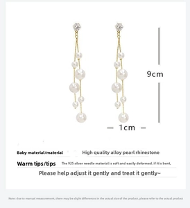 Detailed view of 9cm long tassel earrings with white pearls and sparkling rhinestones