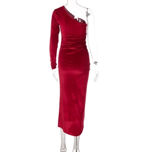 Détail d'une robe asymétrique en velours rouge foncé avec texture plissée élégante