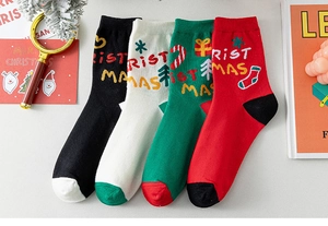 Détail des chaussettes de Noël en tricot avec motifs festifs et lettrage décoratif