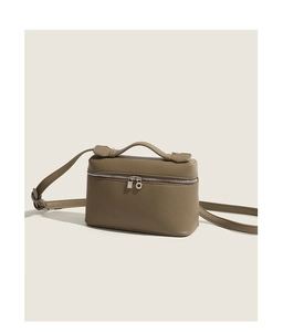 Detail view of khaki leather crossbody bag with top handle and silver hardware