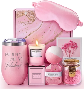 Close-up of pink luxury spa gift set with stainless steel tumbler and aromatic candle