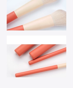 Macro detail of 12-piece coral orange makeup brushes with soft bristles and matte handles