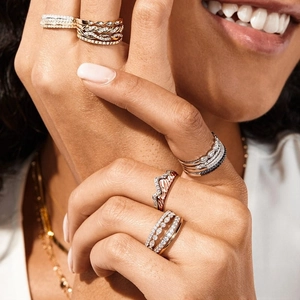 Close-up of stacked rings in gold and silver tones featuring micro-pave crystal accents