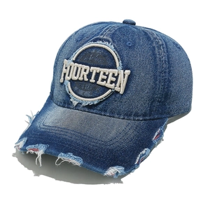 Close-up of distressed denim baseball cap featuring Fourteen embroidery and frayed details