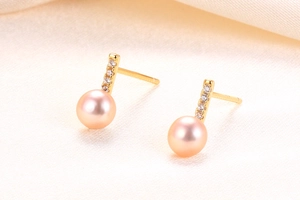 Detailed close-up of pink pearl earrings with gold bar and micro-set zircon accents