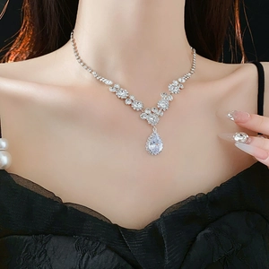 Gros plan du collier en strass en V avec pendentif goutte en cristal sur un mannequin
