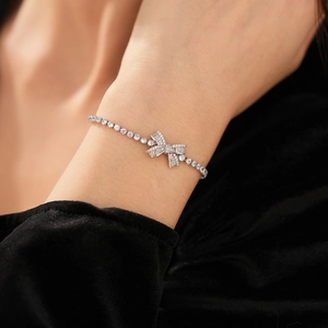 Detailed close-up of a zircon bow bracelet featuring high-quality silver tennis chain