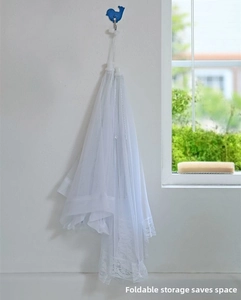 Foldable white mesh food cover with lace trim shown hanging in a storage position
