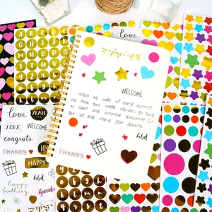 Colorful heart and star stickers with gold letter decals on a spiral notebook