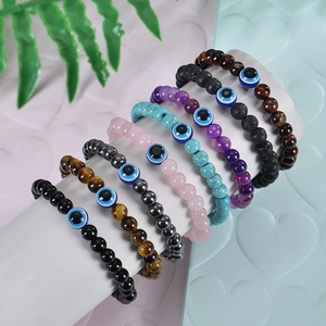 Dettaglio di otto braccialetti di perline evil eye multicolore su un supporto bianco