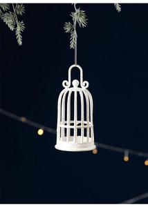 Vintage white birdcage Christmas ornament with glitter finish hanging on pine branch