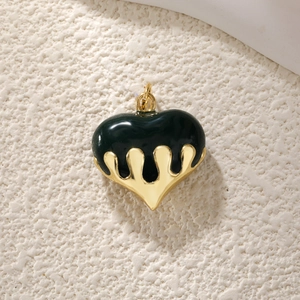Detail view of heart pendant with deep green enamel and golden melting metal drops