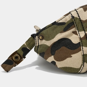 Detailed close-up of camouflage twill canvas texture and vintage bronze metal snap button