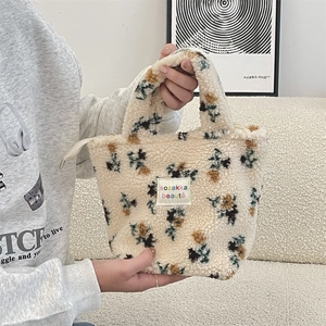Detailierte Textur der cremeweißen Teddy-Fleece Handtasche mit abstrakten Blumen