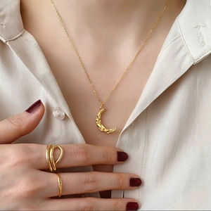 925 silver golden moon pendant necklace and minimalist rings on model wearing beige shirt