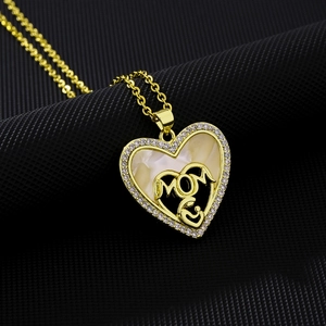 Close-up of gold heart necklace with white mother of pearl and MOM letter engraving
