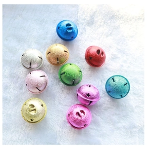 Macro detail of 4cm colorful frosted metal star bells on a white plush background