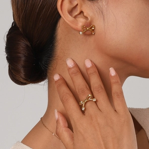 Macro detail of 18k gold plated stainless steel bow ring with sparkling zircon stones